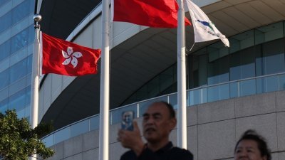 香港《基本法》23条已生效，依法若旅客携带煽动刊物入境又没有合理辩解，会转交警方进一步调查。图为1月18日香港金紫荆广场上飘扬的香港区旗和中国旗。（图取自中央社）