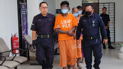 被告那卡拉占（中）身穿橙色扣留服，被警方押往居林推事庭面控。