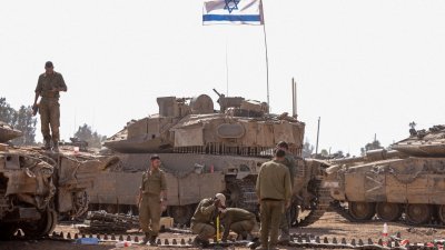 以色列士兵周一在以色列与加沙地带边境附近的军营中，为坦克进行保养作业。（图取自法新社）