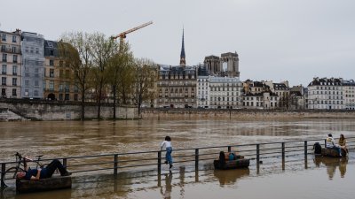 民众在法国首都巴黎塞纳河沿岸被洪水淹没的码头，享受暖和的天气。（图取自法新社）