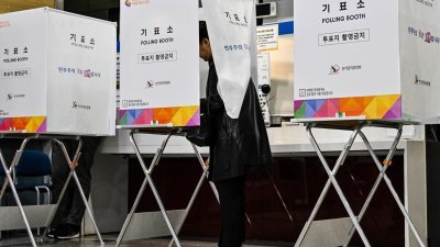 在韩国首尔一投票站，选民在投票。（图取自法新社）