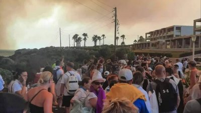 去年7月22日，希腊罗德岛野火肆虐，旅客从酒店撤离。（图取自法新社）