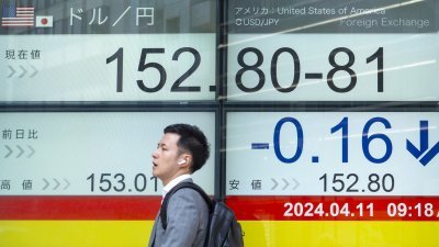 日本东京街道上的电子板，显示周四美元和日圆汇率为1对152.8.（图取自法新社）