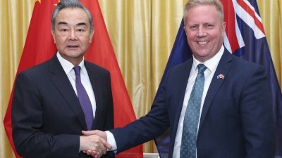 中国外交部长王毅（左）今年3月访问纽西兰，在会晤前与纽西兰贸易部长麦克莱握手。（图取自法新社）