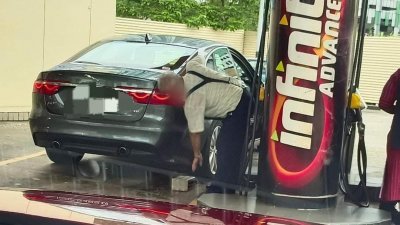 一名驾驶新加坡车牌捷豹(Jaguar)的男子在油站添油时，拿出砖块垫高车身，试图添更多油，引起网民热议。