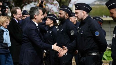 针对巴黎奥运会开幕式前的安全措施，法国内政部长达尔马宁周二访问法国警察河流大队成员。（图取自法新社）