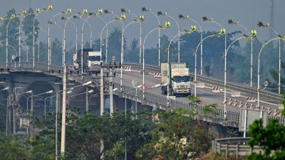 来自缅甸妙瓦底的卡车，周五在“第2友谊大桥”驶向泰国美索镇。（图取自法新社）