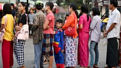 在泰缅边境泰国一侧的美索镇，跨境到泰国的缅甸国民，在7天泰国边境通行证到期前，排队等待返回缅甸。（图取自法新社）