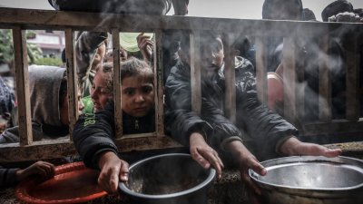 加沙地带南部拉法的巴勒斯坦难民儿童，今年2月19日聚集在一所政府学校领取食物。（图取自法新社）