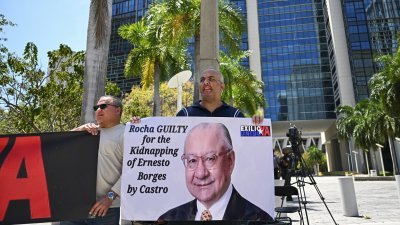 民众周五在美国佛罗里达州迈阿密的法院外抗议，要求对被控为古巴从事间谍活动的美国前驻玻利维亚大使罗查，判处“最高刑期”。（图取自法新社）