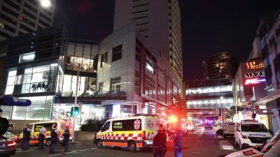 澳洲悉尼的韦斯特菲尔德邦迪枢纽购物中心，周六下午发生致命持刀袭击事件，赶到现场的警方封锁购物中心前的道路，多辆救护车驶入准备载伤者到医院。（图取自法新社）