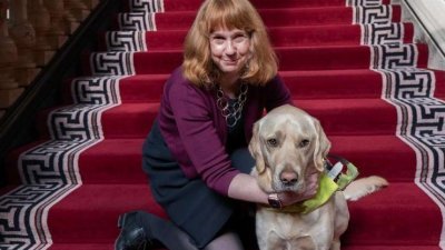 失明的候任英国驻斯洛文尼亚大使哈里森，和她的导盲犬“奥托”在英国外交部拍摄的照片。（图取自英国外交部网站）