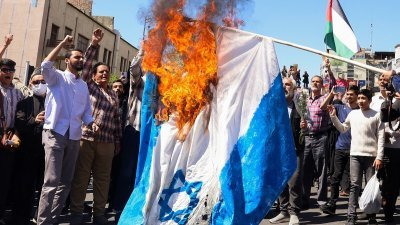 以色列日前空袭伊朗驻叙利亚领事馆造成多名军官丧生，伊朗群众上周五（5日）在首都德黑兰焚烧以色列国旗表达愤怒。（图取自法新社）