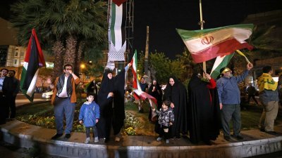 伊朗对以色列发动无人机和导弹袭击后，民众周日聚集在德黑兰巴勒斯坦广场，挥舞伊朗国旗和巴勒斯坦旗。（图取自法新社）