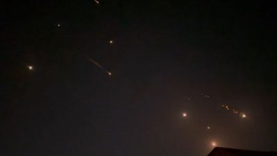 截取自AFPTV 于周日拍摄的影片截图显示，在伊朗袭击以色列期间，巴勒斯坦领土希伯伦的上空被爆炸照亮。（图取自AFPTV/AFP）