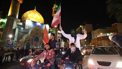 伊朗对以色列发动无人机和导弹袭击后，民众周日聚集在德黑兰巴勒斯坦广场，挥舞伊朗国旗和巴勒斯坦旗欢呼。（图取自法新社）
