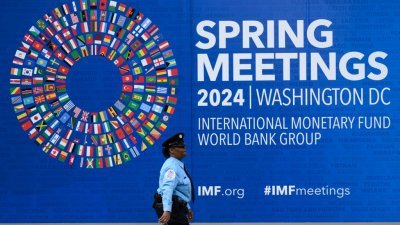 IMF和世行的2024年春季会议周二开幕，美国首都华盛顿的IMF总部外已设置了会议的布景板。（图取自法新社）