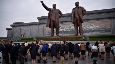 朝鲜民众在平壤万寿台，向已故朝鲜领导人金日成和金正日的雕像鞠躬致敬。（图取自法新社）
