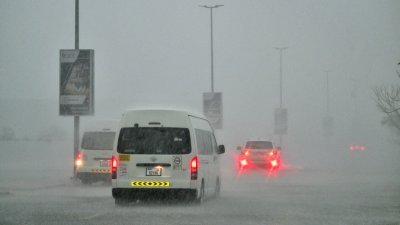 阿联酋周二遭罕见暴雨袭击，迪拜多地道路出现积水，车辆在大雨中缓慢行驶。（图取自法新社）