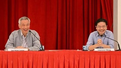 李显龙（左）宣布交棒予黄循财，卸任后将出任国务资政，受访时政评论员纷纷表示，这是意料中事。