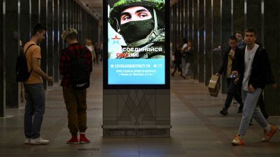 在莫斯科地铁月台上，宣传俄罗斯军队合约兵役的广告电子屏幕。（图取自法新社）