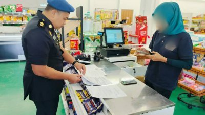 国内贸易及生活成本局执法人员，检查违例超市的1公斤包装津贴食油库存。