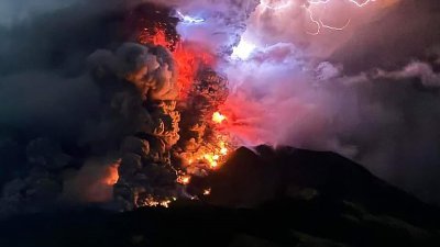 印尼北苏拉威西省的鲁昂火山周三晚喷出热熔岩和烟雾，火山上空被染红并出现闪电交加的震撼画面。（图取自印尼火山和地质灾害减灾中心/法新社）