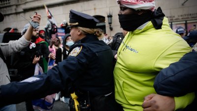 美国纽约市警察周四带走一人时，在哥伦比亚大学外遇到亲巴勒斯坦抗议者。（图取自法新社）