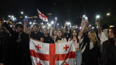 示威者周四在格鲁吉亚首都第比利斯，手持开启闪光灯的智能手机和格鲁吉亚国旗参加示威，对《外国影响透明度法案》表达抗议。（图取自法新社）