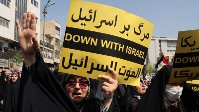 伊朗民众周五在德黑兰的反以色列示威活动中，挥舞巴勒斯坦的旗帜和伊朗国旗。（图取自法新社）