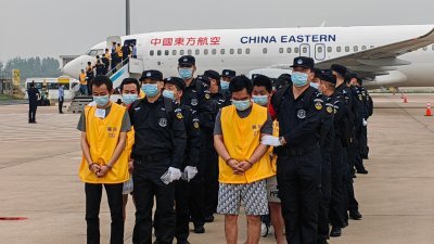 两架中国民航包机周日早降落在湖北武汉天河国际机场，135名中国籍涉赌诈违法犯罪嫌犯被中国公安机关从柬埔寨押解回中国。（图取自中国公安部/中新社）