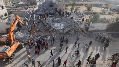 以色列上周日空袭加沙地带南部拉法，救援人员在一栋建筑废墟下搜寻幸存者。（图取自法新社）