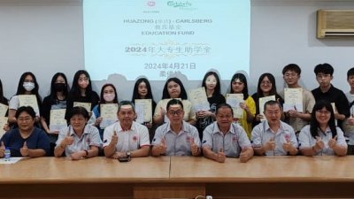 陈文达（前排右4）与柔华总理事移交“华总–Carlsberg大专助学金”给柔州受惠学子。
