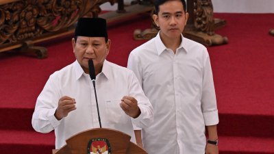 印尼总统当选人普拉博沃（左）周三在选举委员会全体会议上发表讲话，身后为其副手、现总统佐科长子吉布兰。（图取自法新社）