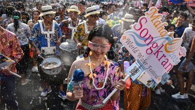 4月12日泼水节前夕，狂欢者在曼谷考山路参加大规模水战游行。（图取自法新社）