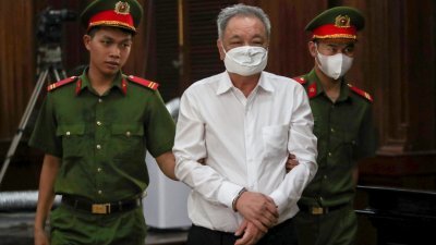 越南饮料大亨陈贵清（中）周四被带入胡志明市法院。（图取自法新社）