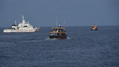2023年8月22日，菲律宾海岸防卫队船只（中）护送菲律宾海军包租的民用船只，在有争议的南中国海向菲律宾“坐滩”仁爱礁的二战废弃军舰运送物资。（图取自法新社档案照）