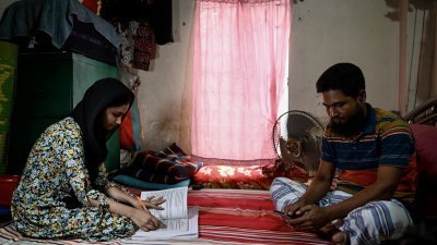 尤索夫和女儿阿克特，周四呆在首都达卡的家中。因为气候酷热，孟加拉国的数百万名学生本周被要求呆在家里。（图取自法新社）