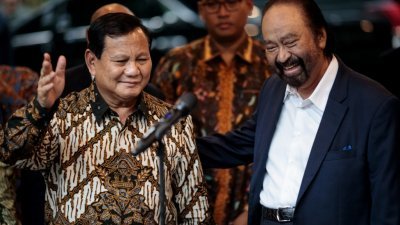 印尼准总统普拉博沃（左）周四与Metro TV所有者、国家民主党党主席苏雅在前者雅加达的家中会面后，在媒体要求下合影。（图取自法新社）