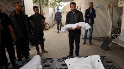 以色列与哈马斯之间的冲突仍在继续，一名男子上周六（27日）在加沙地带南部拉法一家医院的太平间前，抬著一具在以色列夜间轰炸中丧生的儿童尸体。（图取自法新社）