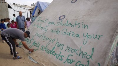 上周六，加沙拉法的一名男子向美国大学亲巴勒斯坦学生的抗议行动写下感谢留言。（图取自法新社）