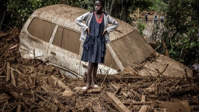 肯尼亚裂谷地区附近的一座水坝在周一决堤，暴雨和泥石流肆虐。在麦马休地区附近的一个村庄，一名女孩站在被泥浆淹没受损的汽车旁。（图取自法新社）