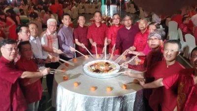 北霹雳中华总商会举办新春晚宴，主桌嘉宾联合捞生。左7起周游斌、洪宝德及廖志明。