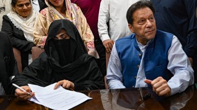 巴基斯坦前总理伊姆兰汗（右）与妻子布希拉被法院裁决他们2018年的婚姻没有完成伊斯兰教规定的等待期，各判处7年徒刑和罚款。（法新社档案照）