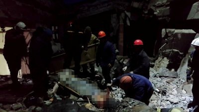 救援人员在利西昌斯克市一家遭受到炮击而被摧毁的面包店内，取出受害者尸体并寻找幸存者。（图取自俄罗斯紧急事务部/法新社）