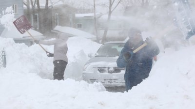 加拿大新斯科舍省的居民，在厚厚的积雪中铲雪，给车子开路。（图取自新斯科舍省政府X帐号）