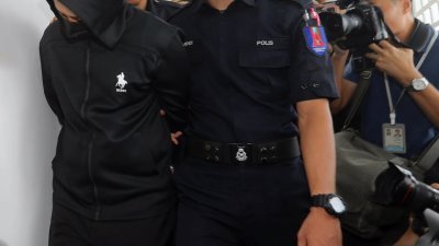 被告（左）穿黑色连帽的外套，同时也戴上口罩，以避开媒体。