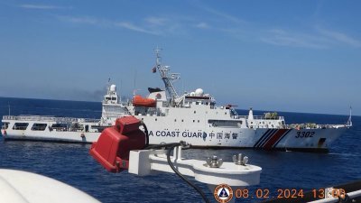 菲律宾海岸警卫队周日发布周四拍摄的照片，显示中国海警船（后）在有争议的南中国海黄岩岛附近，拦截菲律宾海岸警卫队执法舰“马格巴努阿”号。（图取自菲律宾海岸警卫队/法新社）