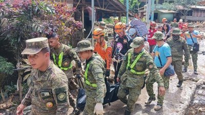 菲律宾棉兰老岛上周二发生土崩事故，图为救援人员上周三在金达沃省马科镇进行搜救行动，在事发的马萨拉村擡出一具尸体。（图取自菲律宾东棉兰老司令部武装部队/法新社）
