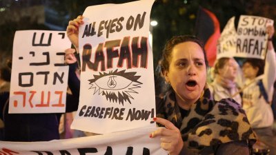 以色列左翼活动人士当地时间周二晚，在特拉维夫的基里亚军事基地（国防部）外抗议加沙地带的战争和计划在拉法进行的地面行动。（图取自法新社）